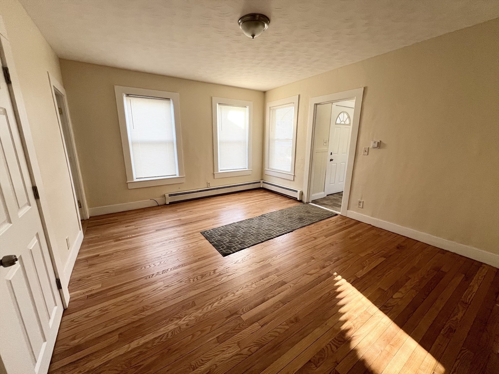 315 Main Street, Unit 1 Springfield, MA 01151 - Photo 4 of 10 a view of an empty room with wooden floor and a window