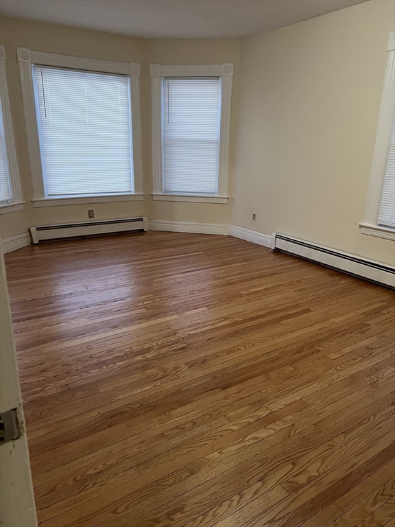 315 Main Street, Unit 1 Springfield, MA 01151 - Photo 5 of 10 an empty room with wooden floor and windows