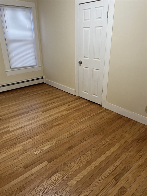 315 Main Street, Unit 1 Springfield, MA 01151 - Photo 8 of 10 an empty room with wooden floor and windows