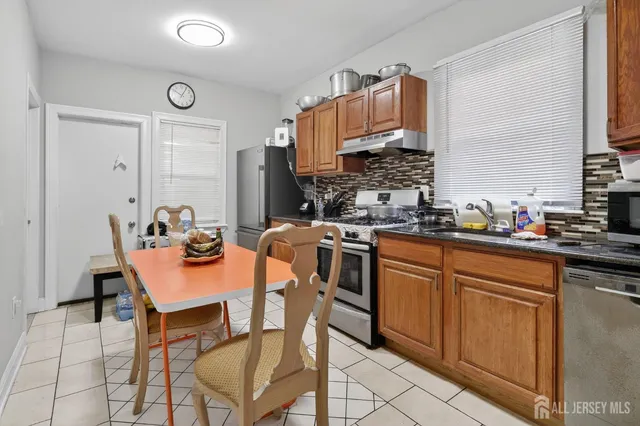 a kitchen with a sink chairs and cabinets