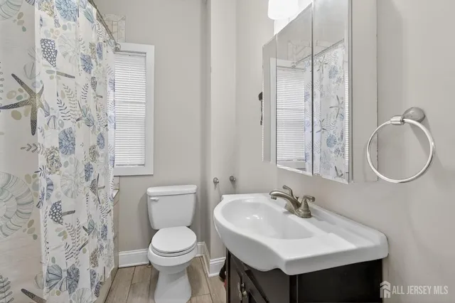 a bathroom with a sink toilet and a mirror