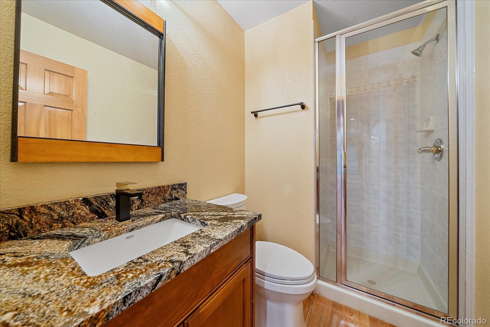 9948 South Turkey Creek Road Conifer, CO 80433 - Photo 20 of 50 a bathroom with a granite countertop sink toilet and shower