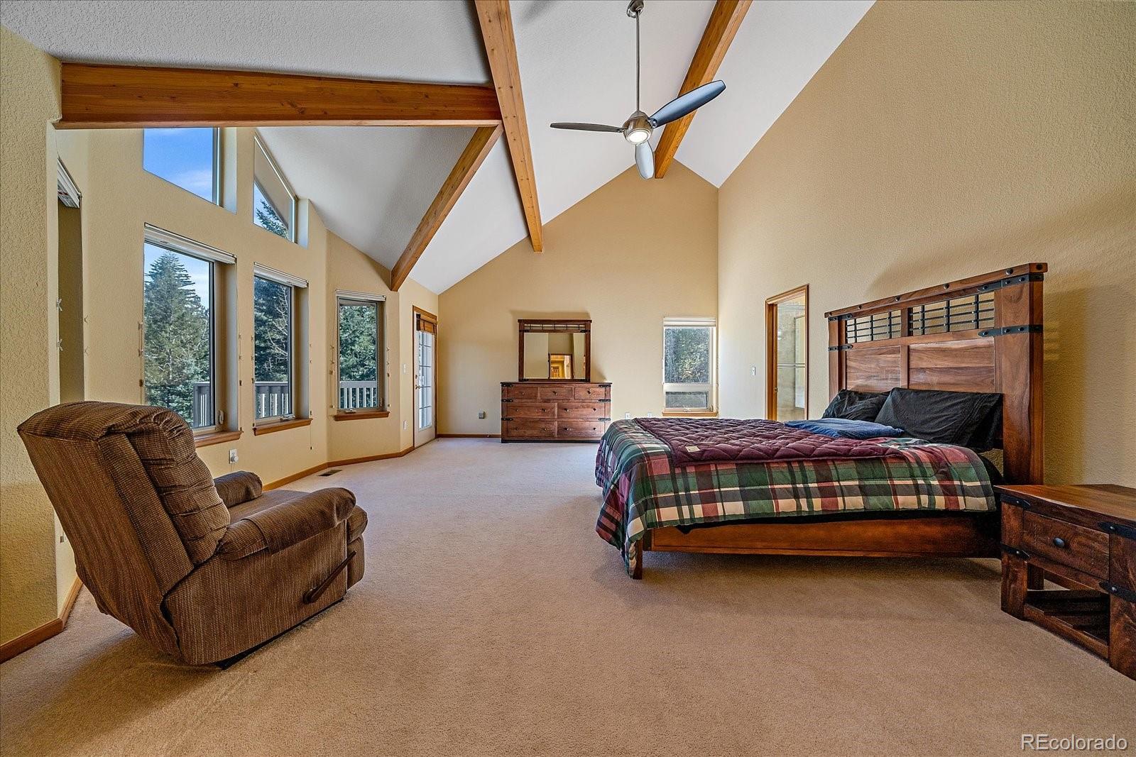 9948 South Turkey Creek Road Conifer, CO 80433 - Photo 25 of 50 a bedroom with bed and balcony with furniture