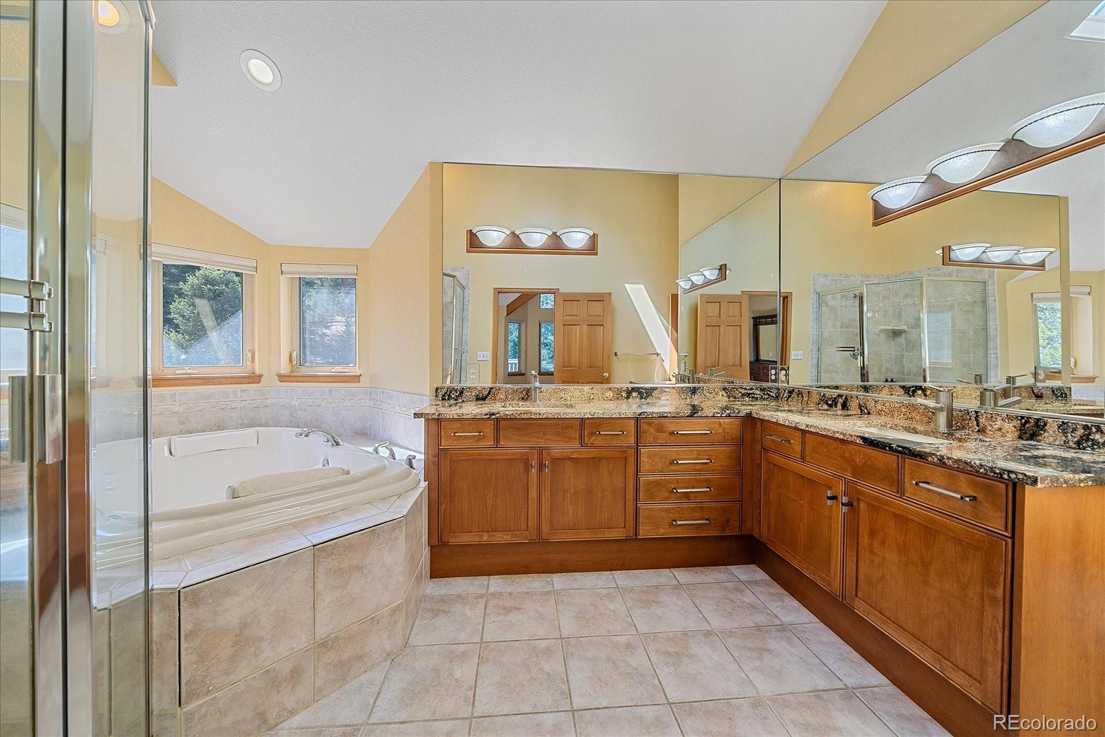 9948 South Turkey Creek Road Conifer, CO 80433 - Photo 28 of 50 a large bathroom with a sink a large mirror and a bathtub