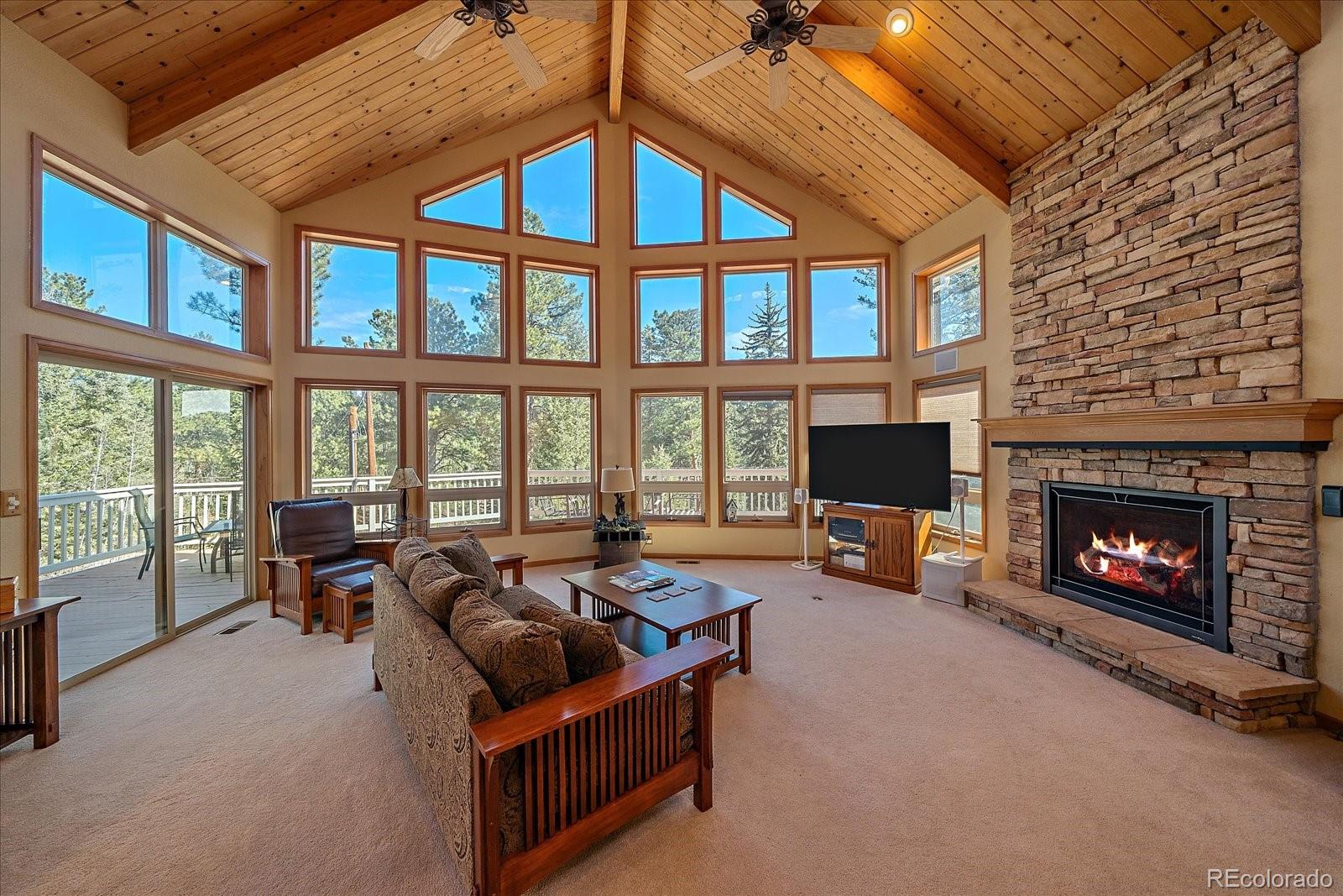 9948 South Turkey Creek Road Conifer, CO 80433 - Photo 3 of 50 a living room with furniture and a fireplace
