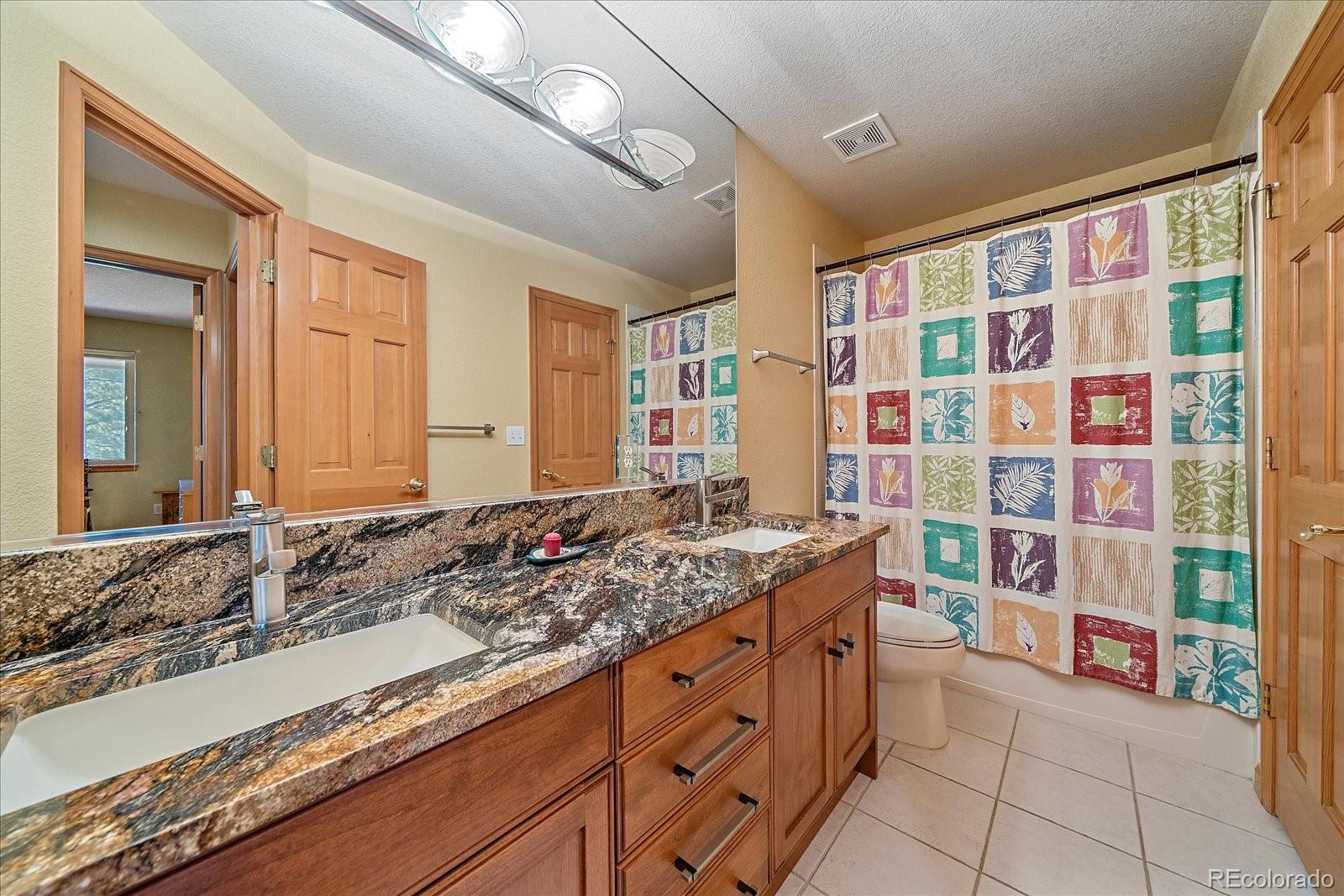 9948 South Turkey Creek Road Conifer, CO 80433 - Photo 35 of 50 a bathroom with a granite countertop sink and a mirror