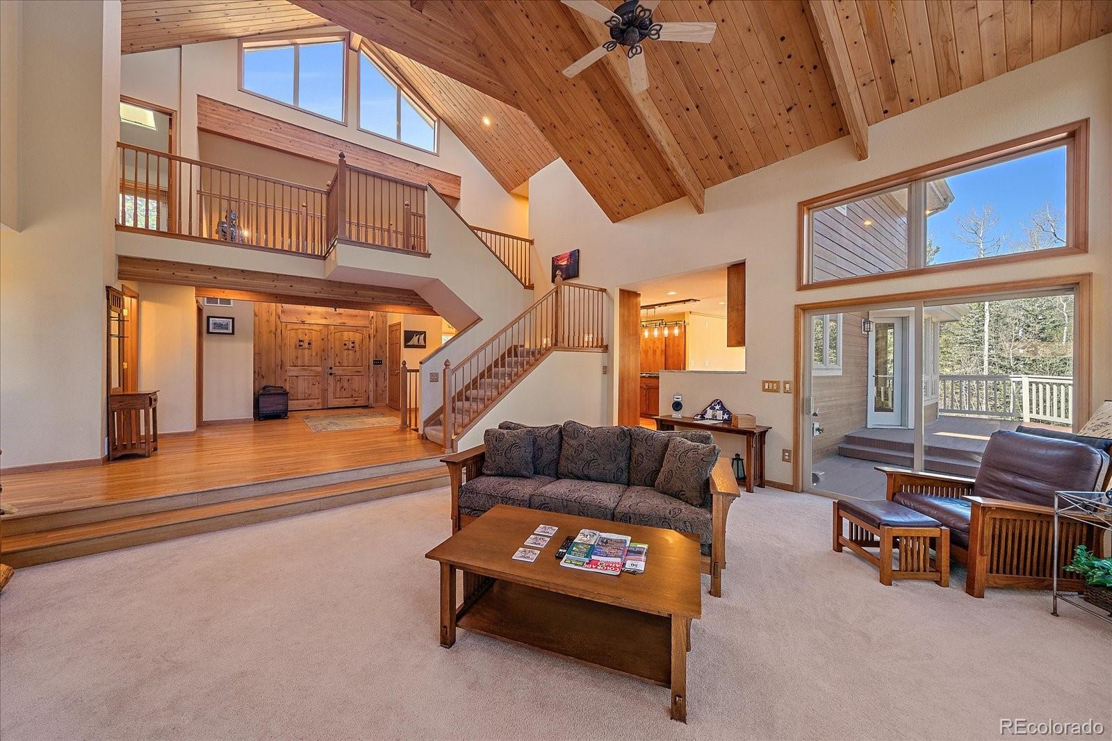 9948 South Turkey Creek Road Conifer, CO 80433 - Photo 5 of 50 a living room with furniture a fireplace and a large window