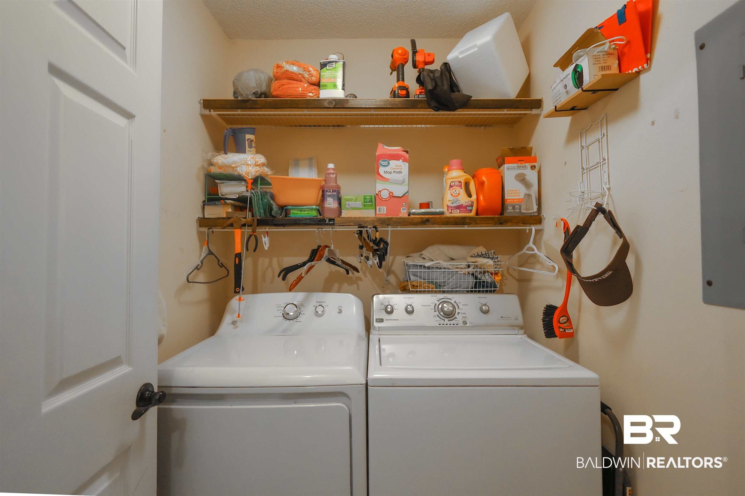 7790 Audubon Drive Foley, AL 36535 - Photo 32 of 39 Laundry area featuring a side-by-side washer and dryer, paired with two wall-mounted wood-finish shelves for storage