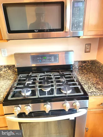 a view of a kitchen with wooden cabinet and a refrigerator