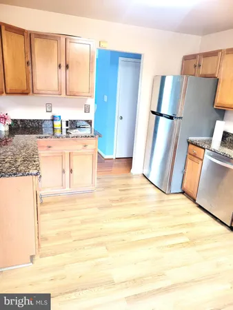 a view of a kitchen with wooden floor and a sink