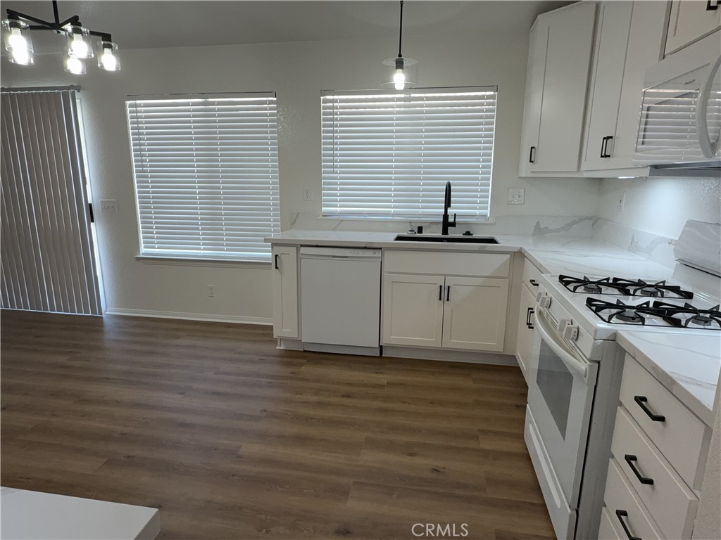 12590 Cobalt Road Victorville, CA 92392 - Photo 19 of 37 a kitchen with stainless steel appliances granite countertop a sink cabinets and a wooden floor