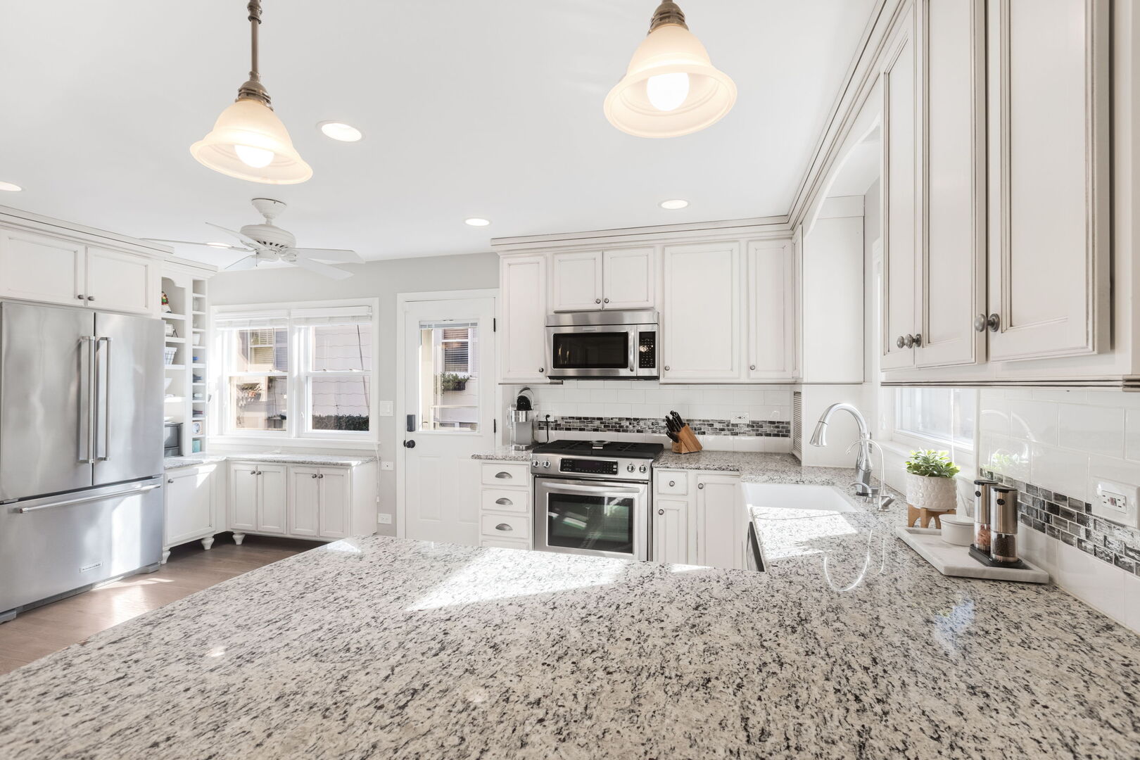640 South Grove Avenue Barrington, IL 60010 - Photo 6 of 24 a kitchen with granite countertop a refrigerator oven a sink dishwasher and white cabinets with wooden floor