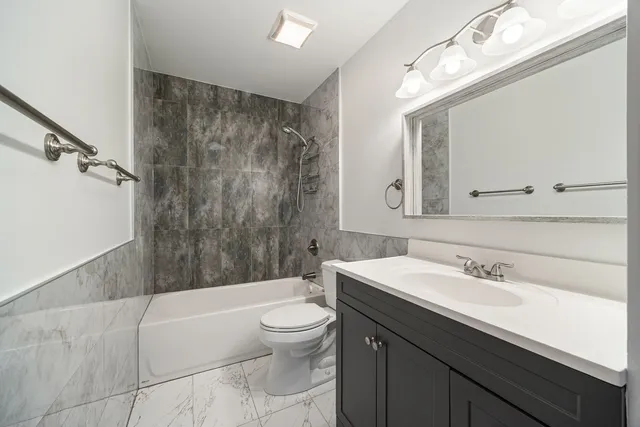 a bathroom with a sink a toilet a mirror and bathtub