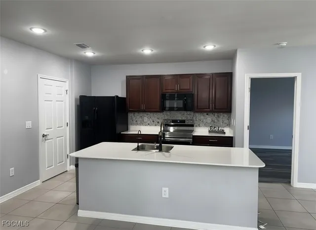 a kitchen with stainless steel appliances a refrigerator sink and microwave