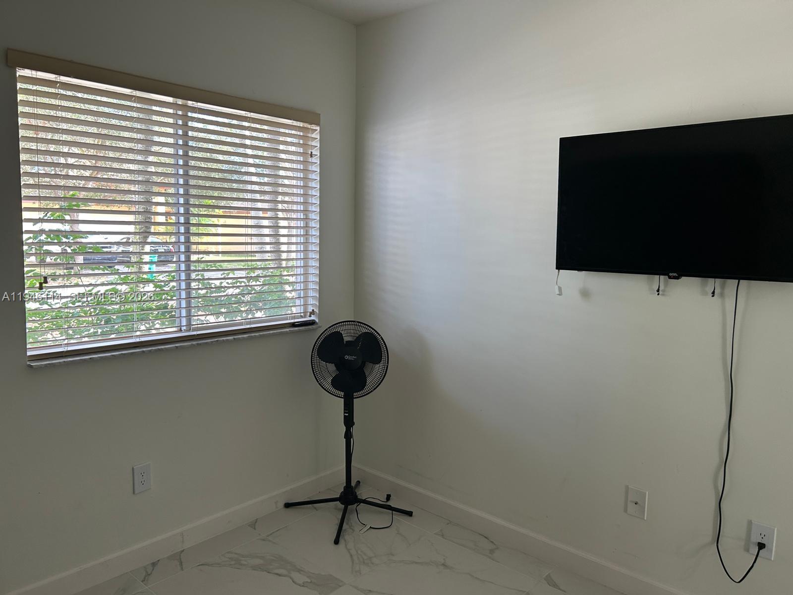 22844 Southwest 114th Avenue Miami, FL 33170 - Photo 20 of 40 a room with a flat screen tv and a large window