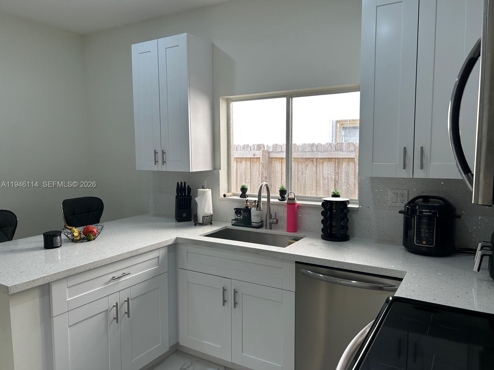 22844 Southwest 114th Avenue Miami, FL 33170 - Photo 35 of 40 a kitchen with a sink a stove and cabinets