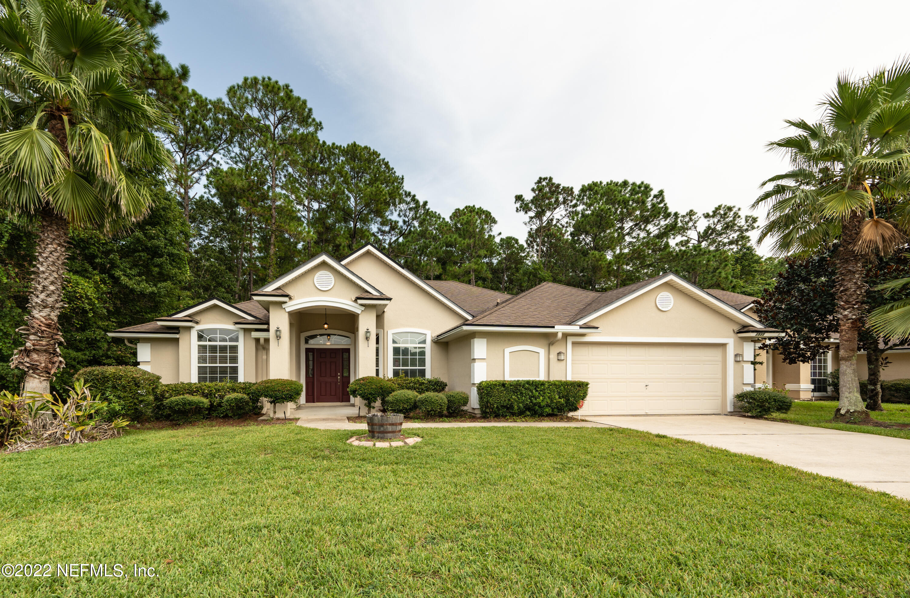a front view of a house with a garden and trees