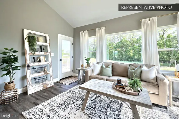 a living room with furniture wooden floor and a large window