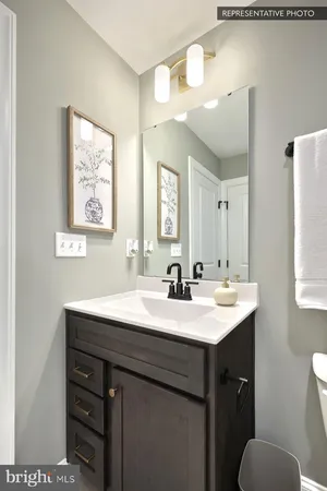 a bathroom with a sink a toilet a mirror and a window