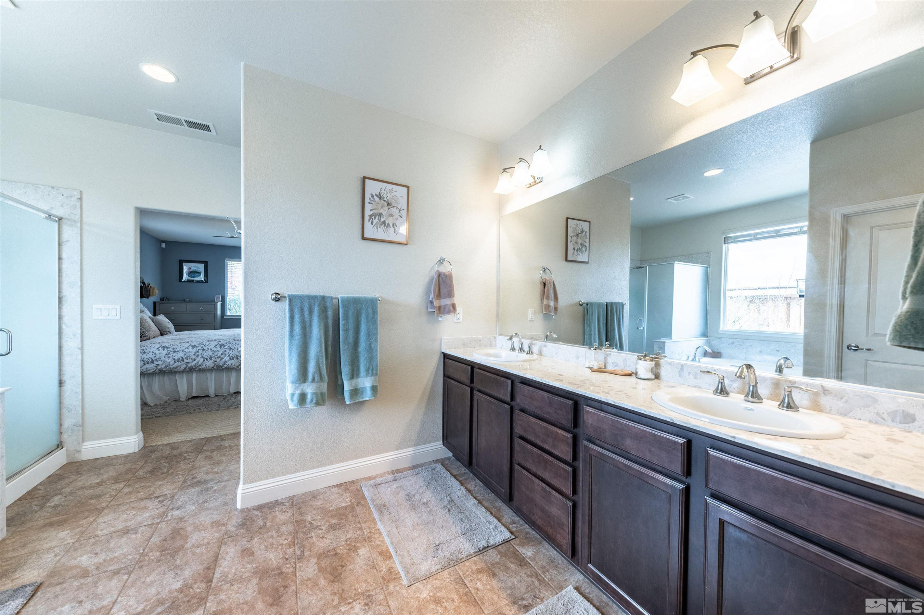 7080 Truth Drive Sparks, NV 89436 - Photo 19 of 40 a spacious bathroom with a granite countertop sink and a mirror