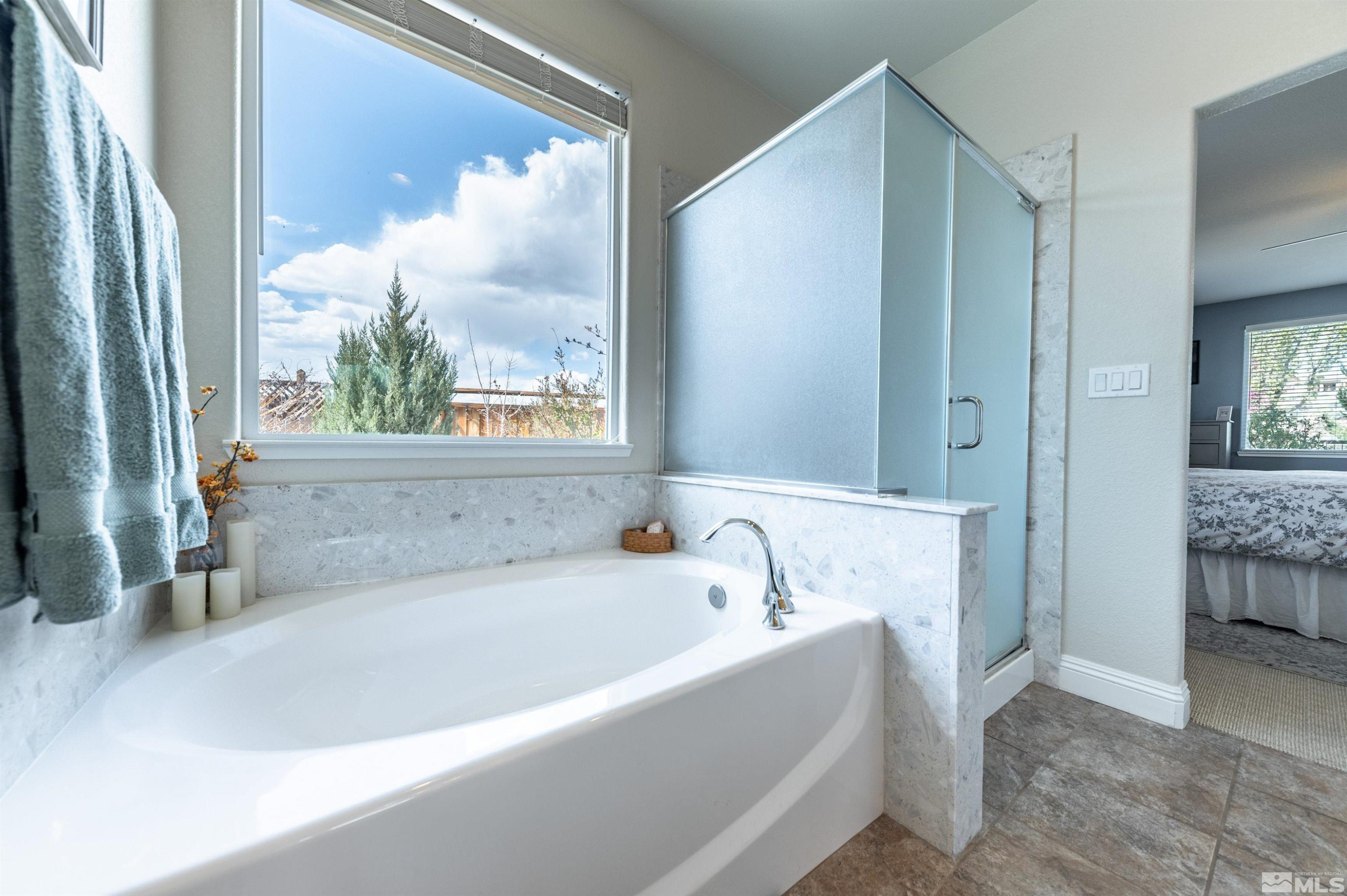 7080 Truth Drive Sparks, NV 89436 - Photo 20 of 40 a white bath tub sitting in a bathroom next to a window