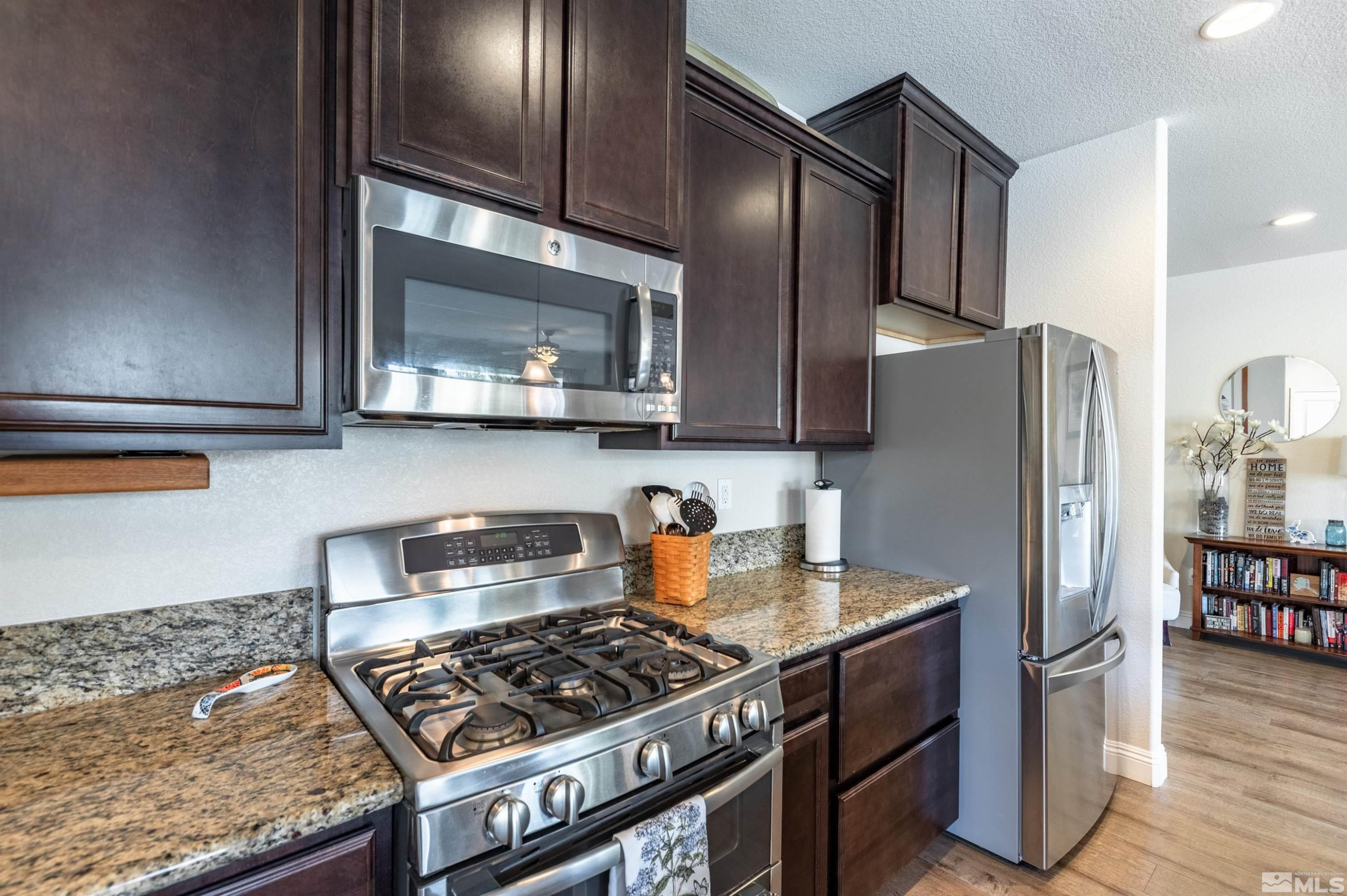 7080 Truth Drive Sparks, NV 89436 - Photo 10 of 40 a kitchen with stainless steel appliances granite countertop a stove a refrigerator and a microwave