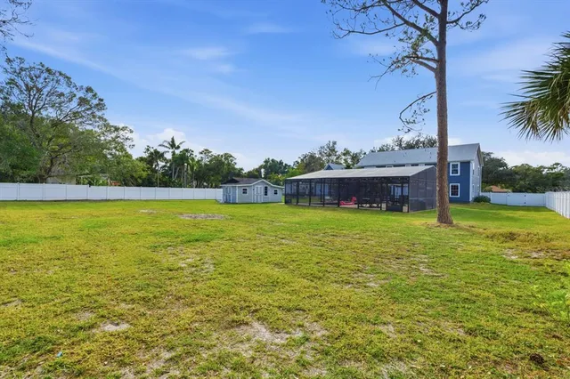 an aerial view of residential houses with outdoor space and trees