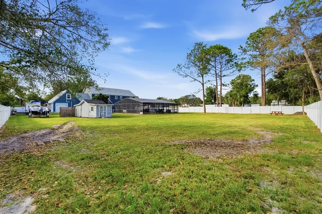 an aerial view of residential houses with outdoor space and trees