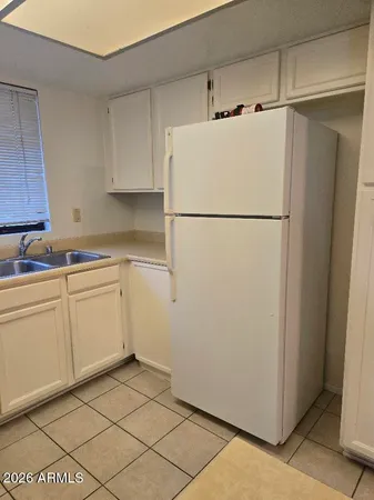 a white refrigerator freezer and a stove sitting inside of a kitchen