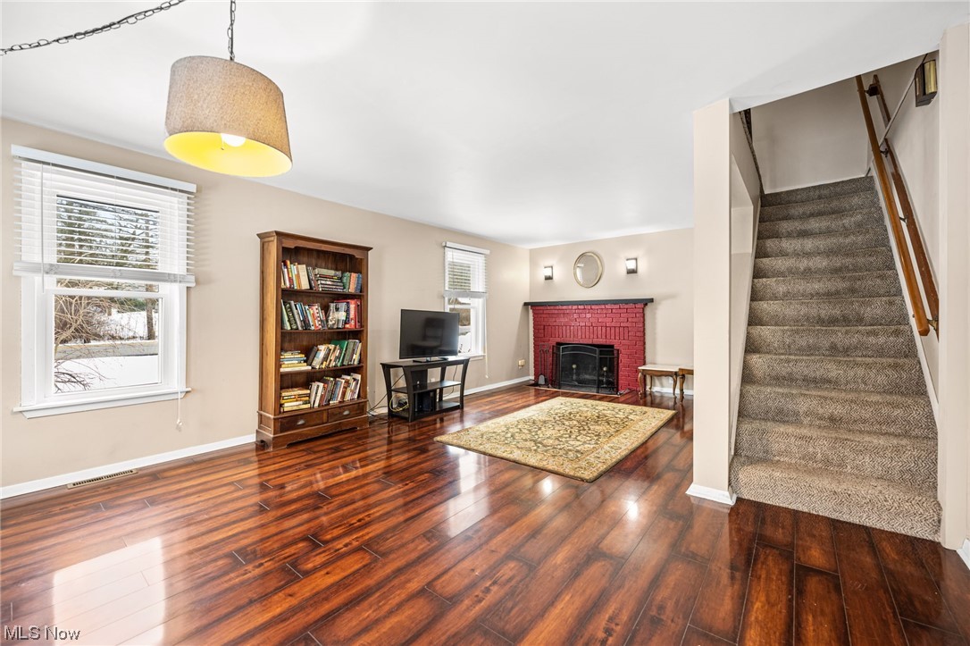 2986 Worrell Road Willoughby, OH 44094 - Photo 15 of 36 Unfurnished living room with dark hardwood / wood-style flooring, a healthy amount of sunlight, and a brick fireplace