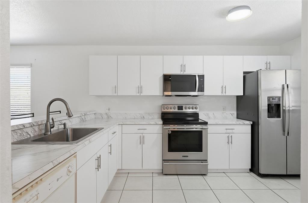 175 Kings Highway, Unit 328 Punta Gorda, FL 33983 - Photo 5 of 41 a kitchen with cabinets stainless steel appliances and a sink