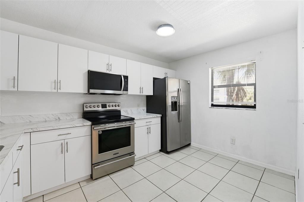 175 Kings Highway, Unit 328 Punta Gorda, FL 33983 - Photo 6 of 41 a kitchen with white cabinets and stainless steel appliances