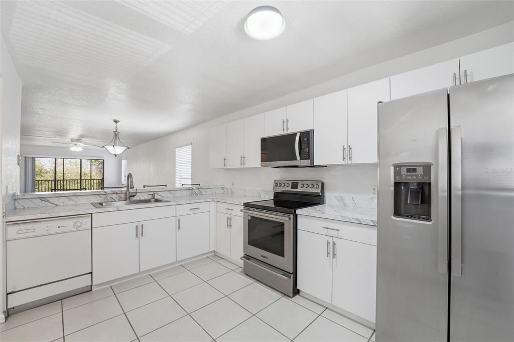175 Kings Highway, Unit 328 Punta Gorda, FL 33983 - Photo 7 of 41 a kitchen with granite countertop white cabinets and white appliances