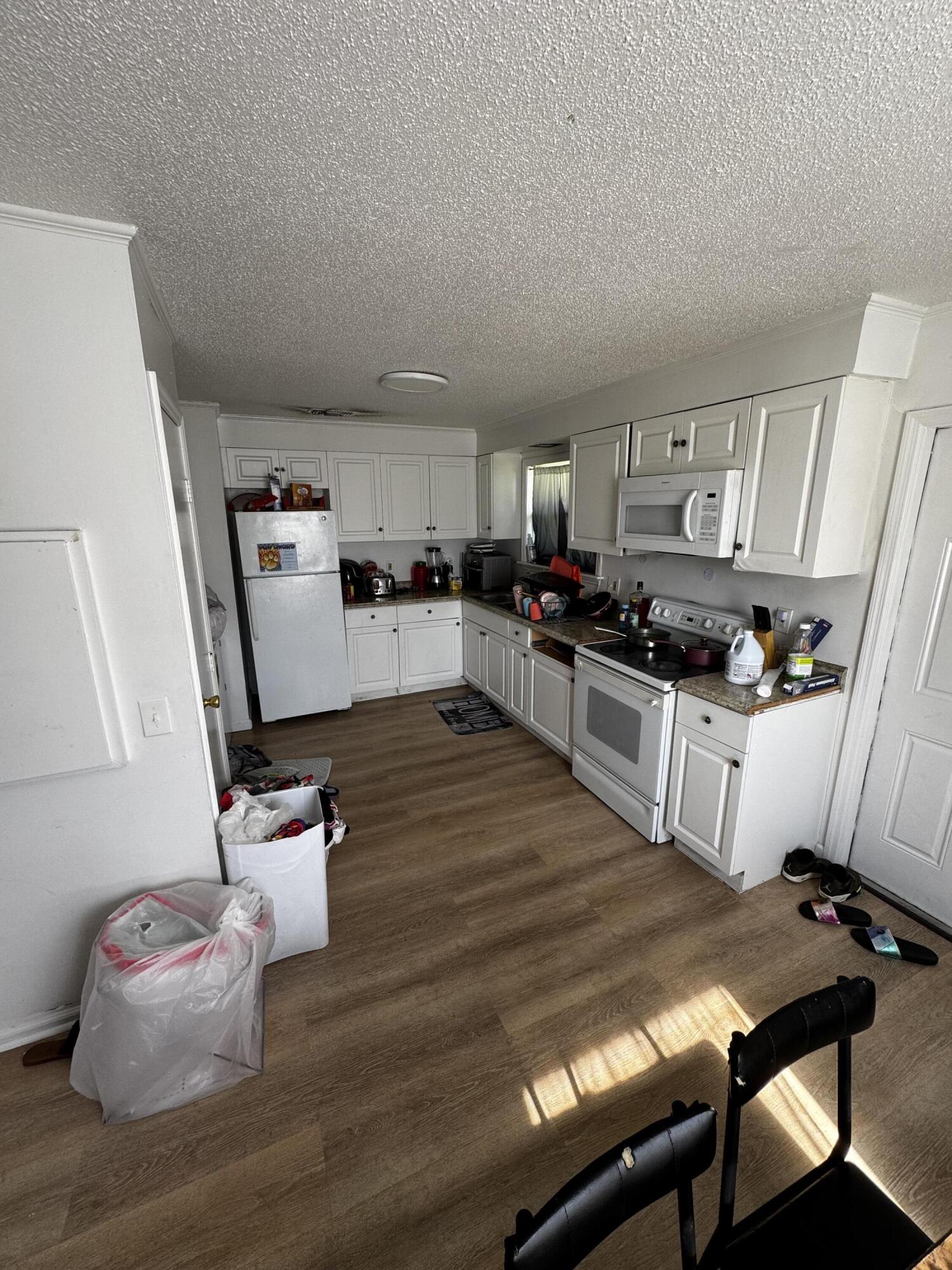 1464 West 32nd Street Riviera Beach, FL 33404 - Photo 3 of 6 a kitchen with sink refrigerator and stove
