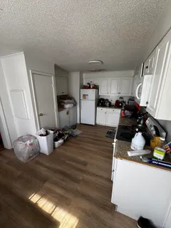 a kitchen with a sink appliances and wooden floor