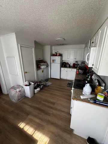 a kitchen with a sink appliances and wooden floor
