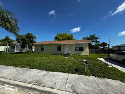 a front view of a house with a garden and yard