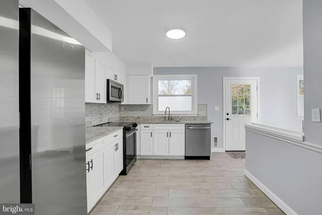 a kitchen with a sink stove top oven and cabinets