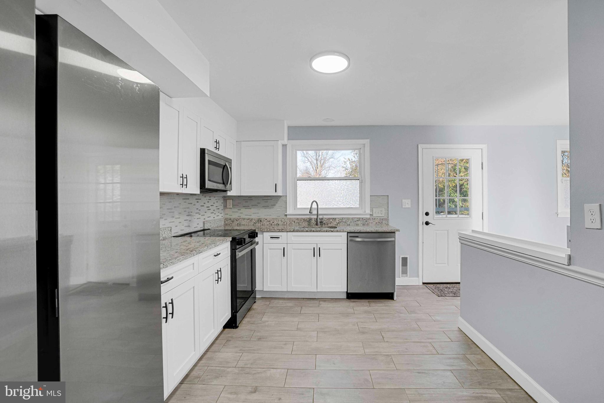5922 Baltimore Street Baltimore, MD 21207 - Photo 11 of 33 a kitchen with a sink stove top oven and cabinets