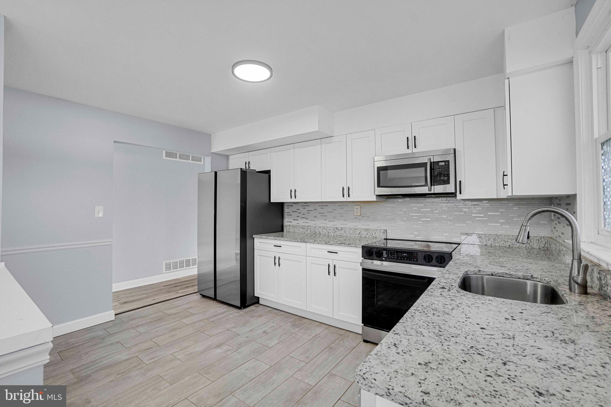5922 Baltimore Street Baltimore, MD 21207 - Photo 12 of 33 a kitchen with stainless steel appliances granite countertop a refrigerator stove and sink