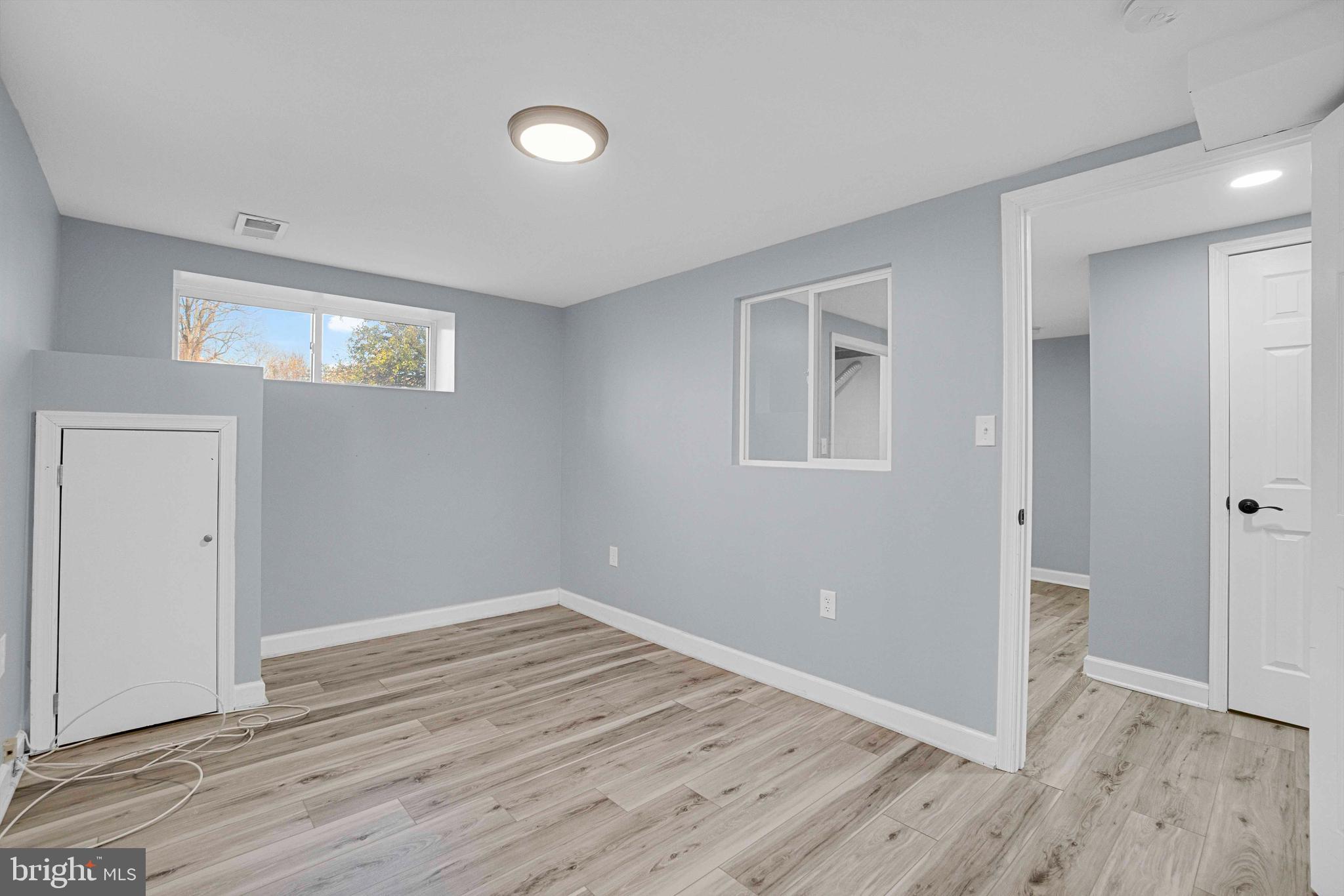 5922 Baltimore Street Baltimore, MD 21207 - Photo 21 of 33 a view of an empty room with wooden floor and a window