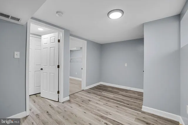a view of empty room with wooden floor