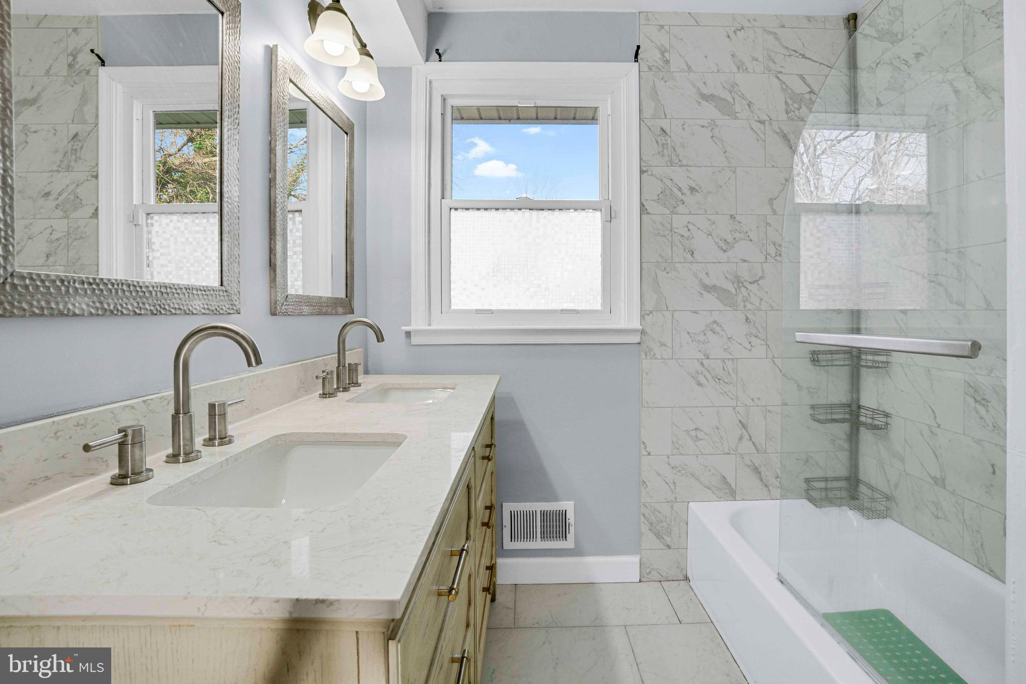 5922 Baltimore Street Baltimore, MD 21207 - Photo 27 of 33 a bathroom with a sink double vanity granite tub shower and a mirror