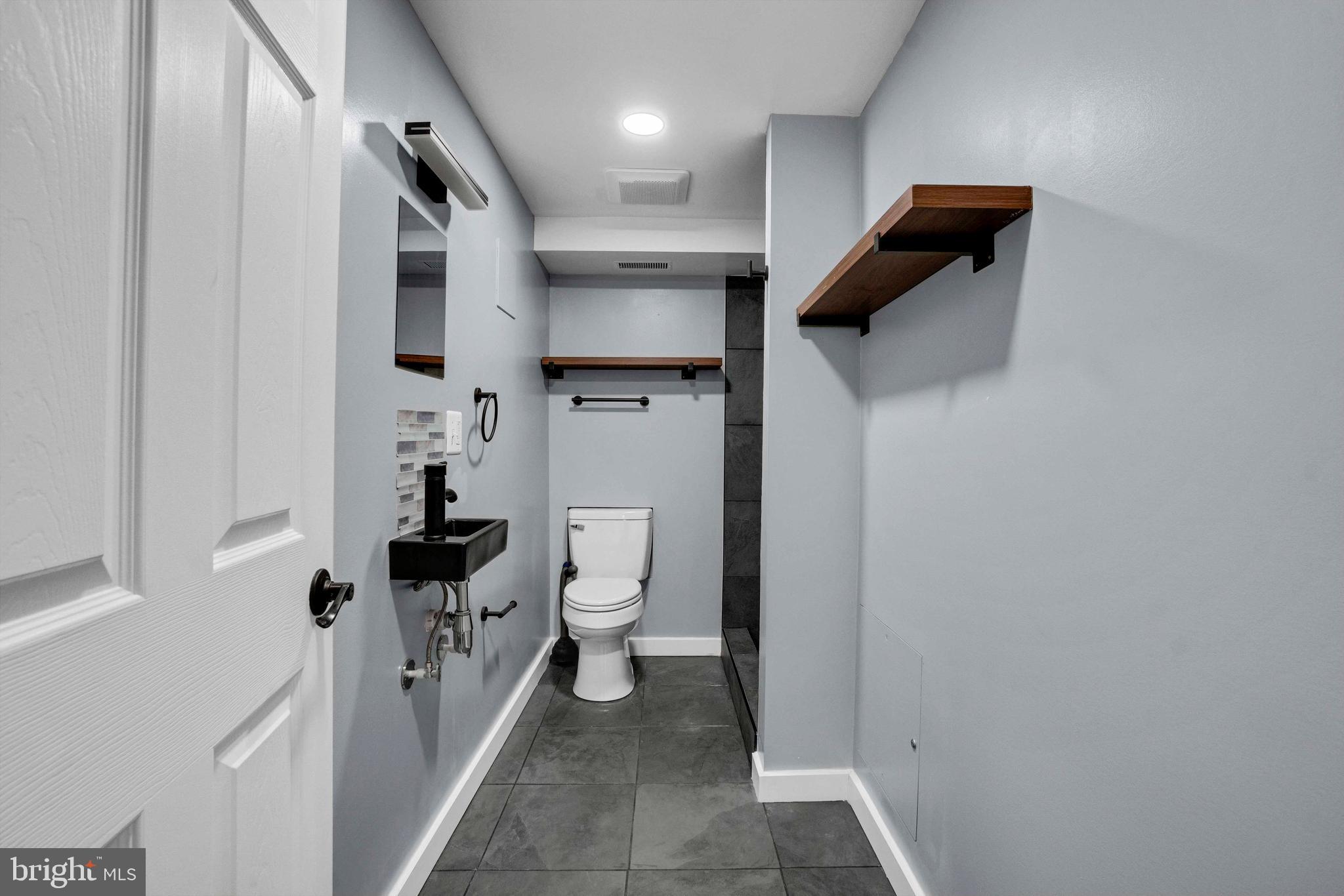 5922 Baltimore Street Baltimore, MD 21207 - Photo 28 of 33 a bathroom with a toilet and a shower