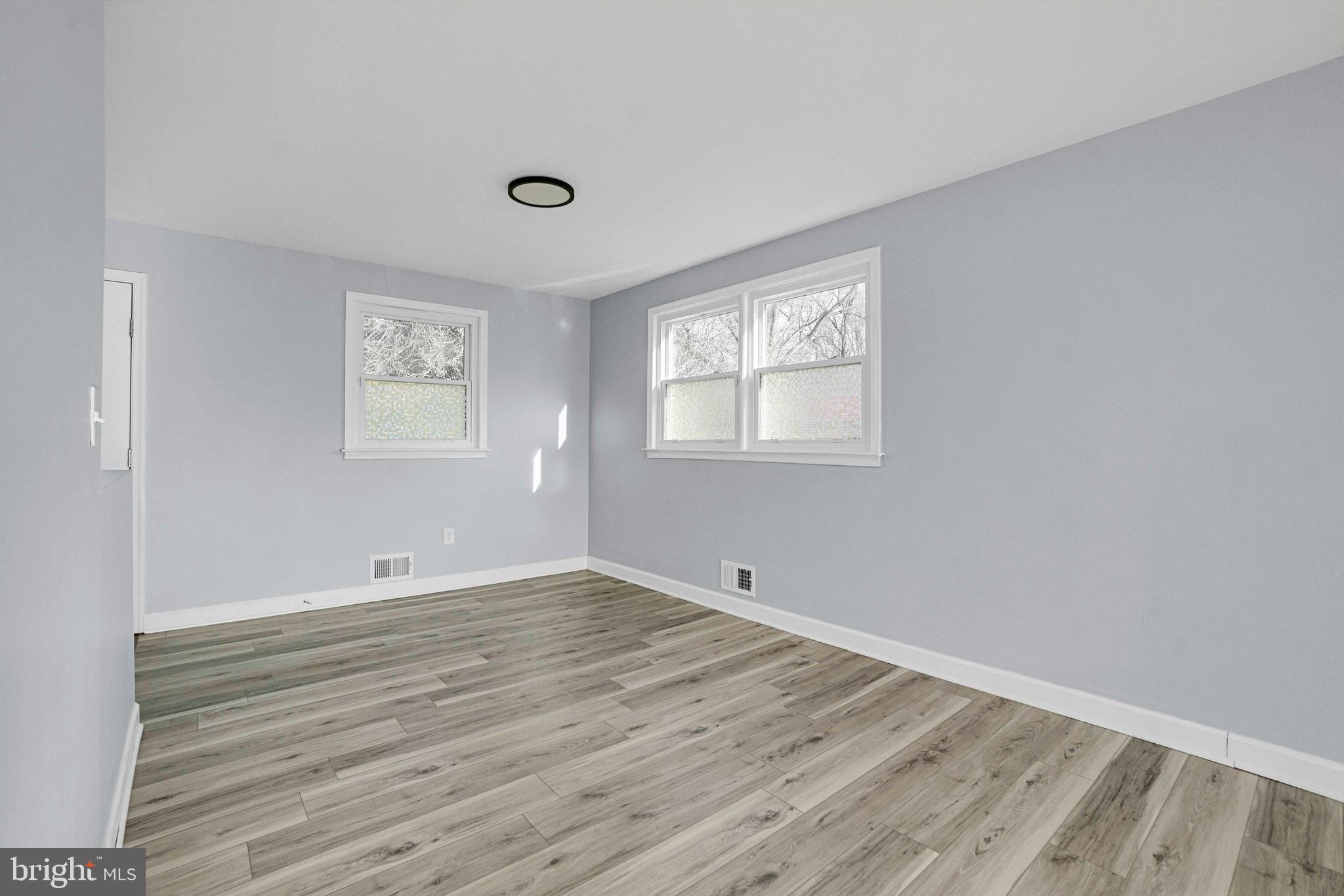 5922 Baltimore Street Baltimore, MD 21207 - Photo 6 of 33 a view of an empty room with wooden floor and a window