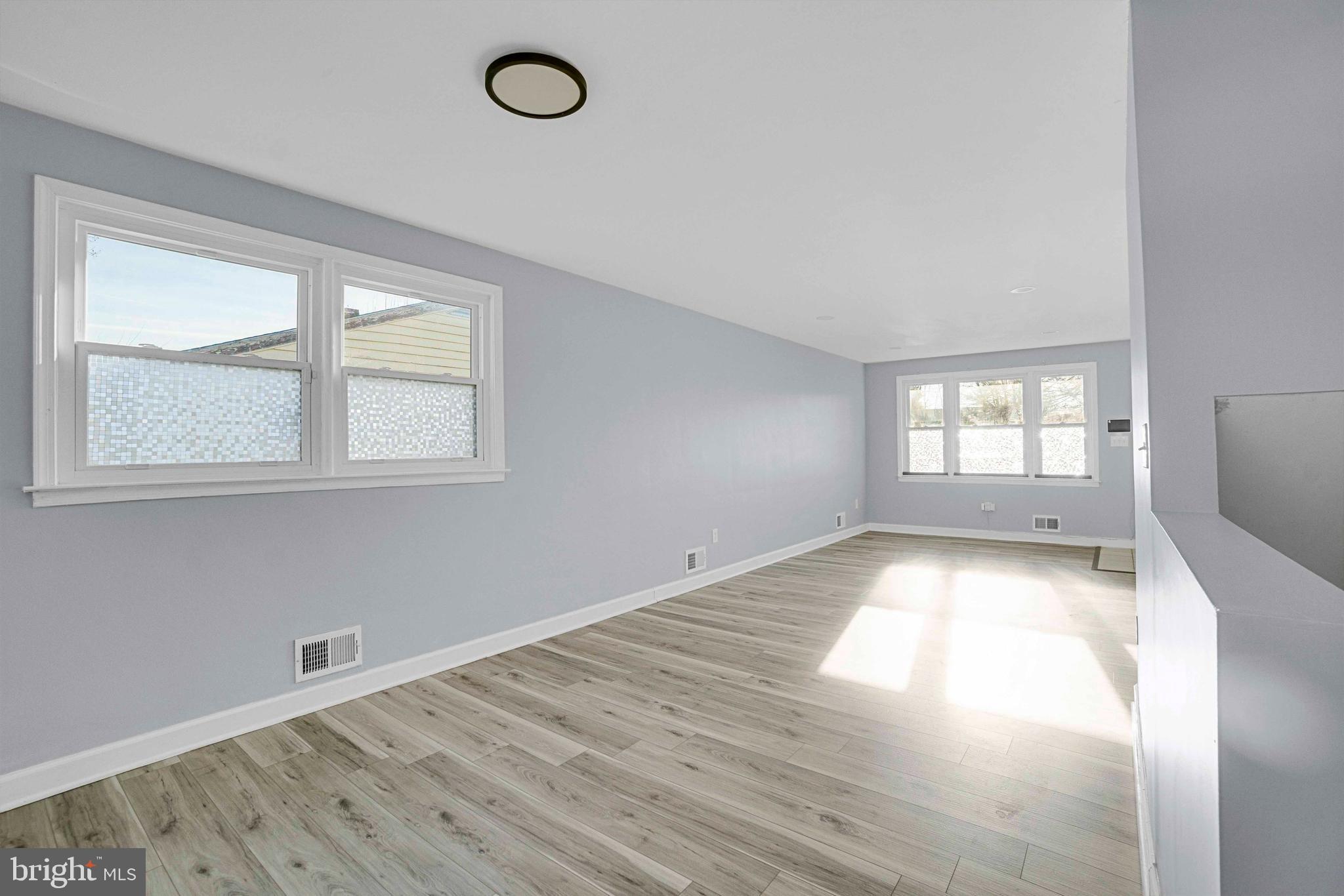 5922 Baltimore Street Baltimore, MD 21207 - Photo 7 of 33 an empty room with wooden floor and windows