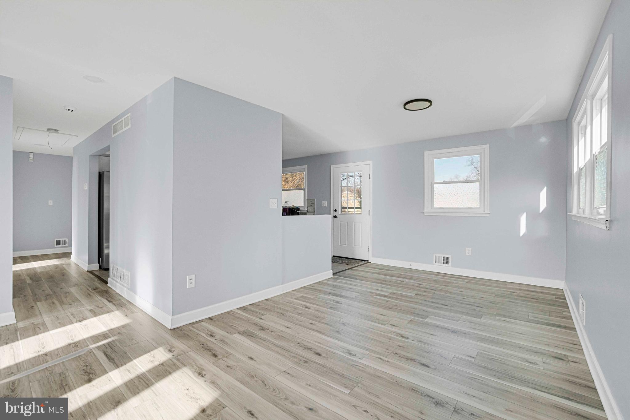 5922 Baltimore Street Baltimore, MD 21207 - Photo 8 of 33 a view of an empty room with wooden floor and a window