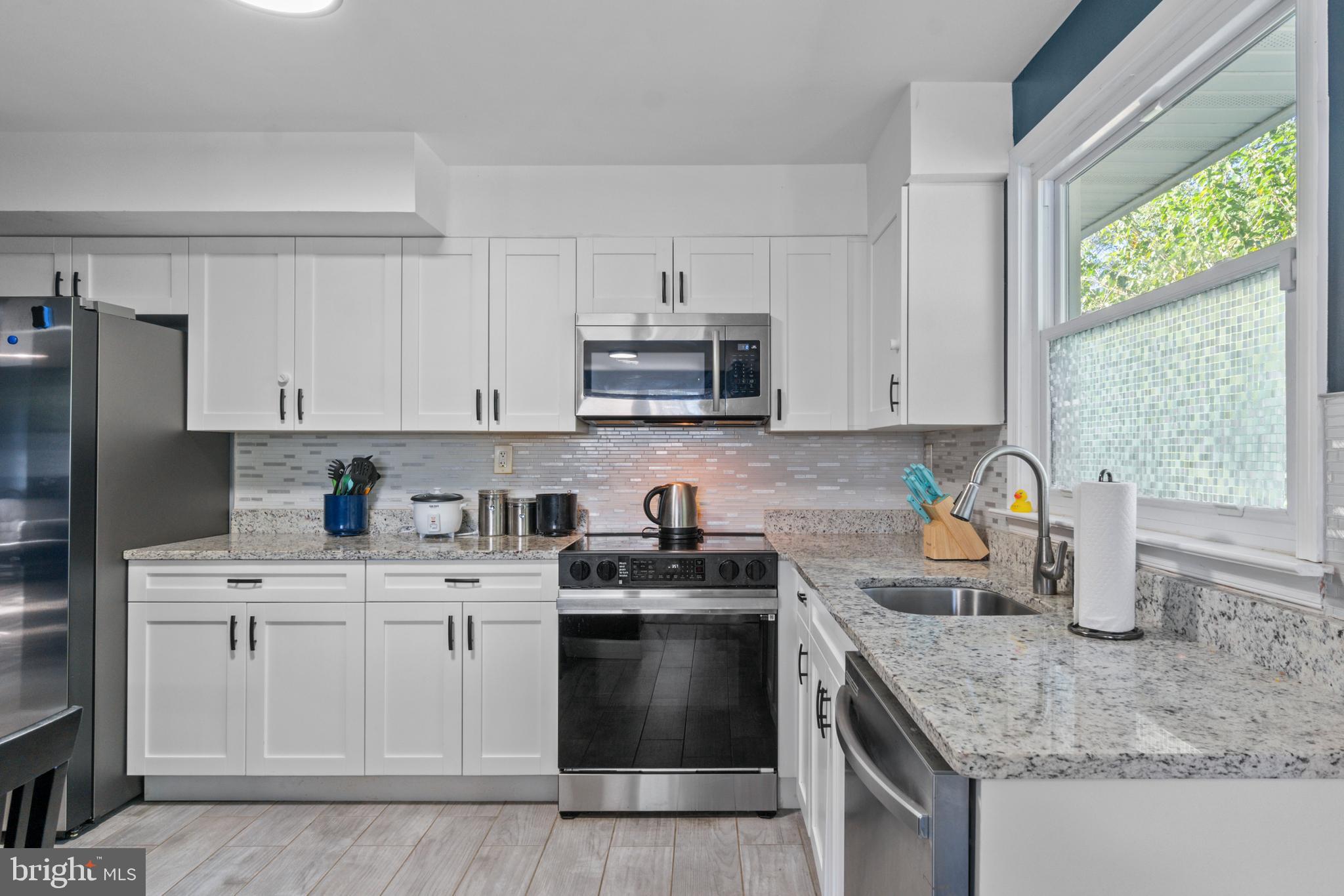 5922 Baltimore Street Baltimore, MD 21207 - Photo 10 of 33 a kitchen with stainless steel appliances granite countertop a sink stove and refrigerator