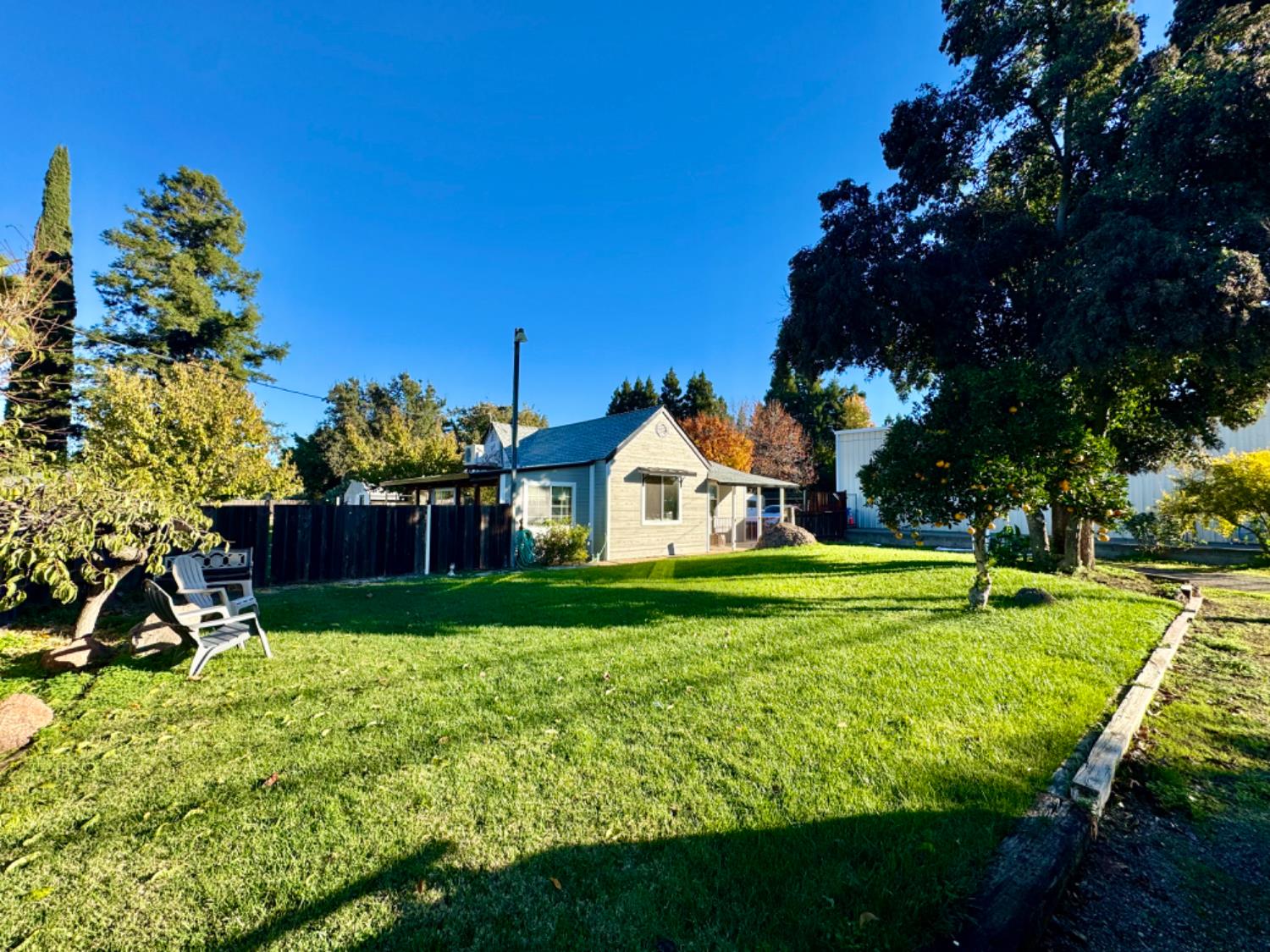 a view of a big house with a big yard and a large trees