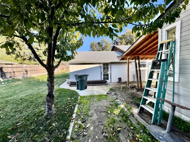 a view of a house with backyard and sitting area